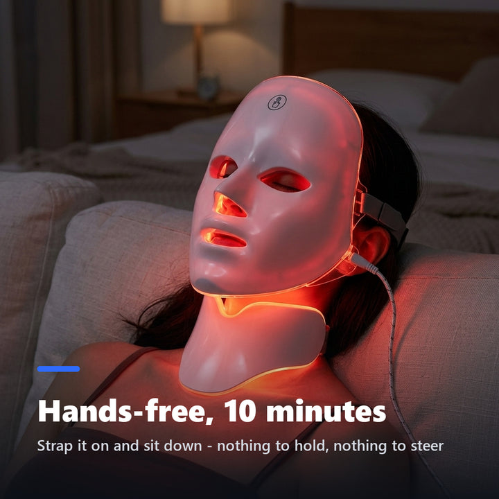 Woman wearing an LED face mask glowing red while reclining